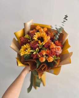 Strauß aus Sonnenblumen und orangefarbenen Rosen (Demo-Foto)
